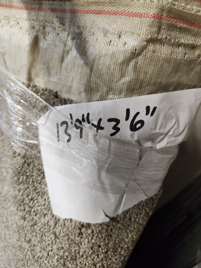 A Flooring CLEARANCE Carpet Remnant 13'9" x 3'6", Medium Plie Grey, wrapped in plastic with labeled dimensions.
