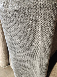 A close-up of the Flooring CLEARANCE Carpet Remnant 4' X 11" 10' in grey, rolled on a concrete floor.