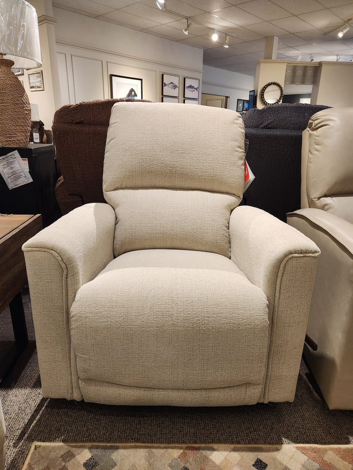 A La-Z-Boy 803 Cade Rocker Recliner in beige is showcased in a furniture showroom with chairs behind it.