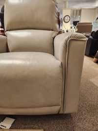 The La-Z-Boy 803 Cade Rocker Recliner, in beige leather, is showcased in a showroom among other chairs.