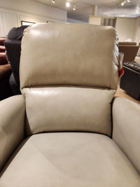 Close-up view of the La-Z-Boy 803 Cade Rocker Recliner in beige leather, displayed in a furniture showroom.