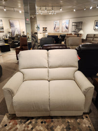 The La-Z-Boy 803 Cade Manual Reclining Loveseat in beige offers functional luxury among other sofas in the showroom.