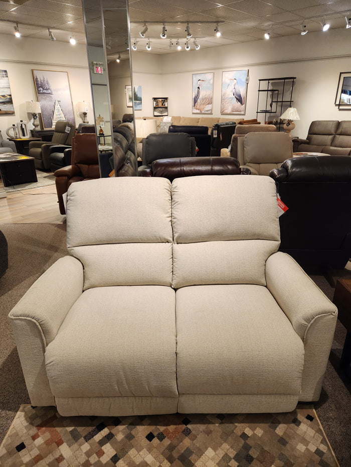 The La-Z-Boy 803 Cade Manual Reclining Loveseat in beige offers functional luxury among other sofas in the showroom.