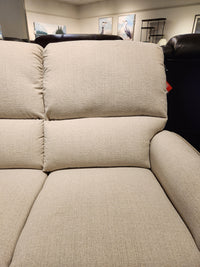 Close-up of the La-Z-Boy 803 Cade Manual Reclining Loveseat with plush cushions in a stylish showroom.