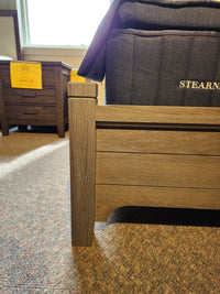 Close-up of Vaughan Bassett 740 Bungalow Arch King Bed’s wooden corner, arched headboard, bedding, and nightstand on sale.