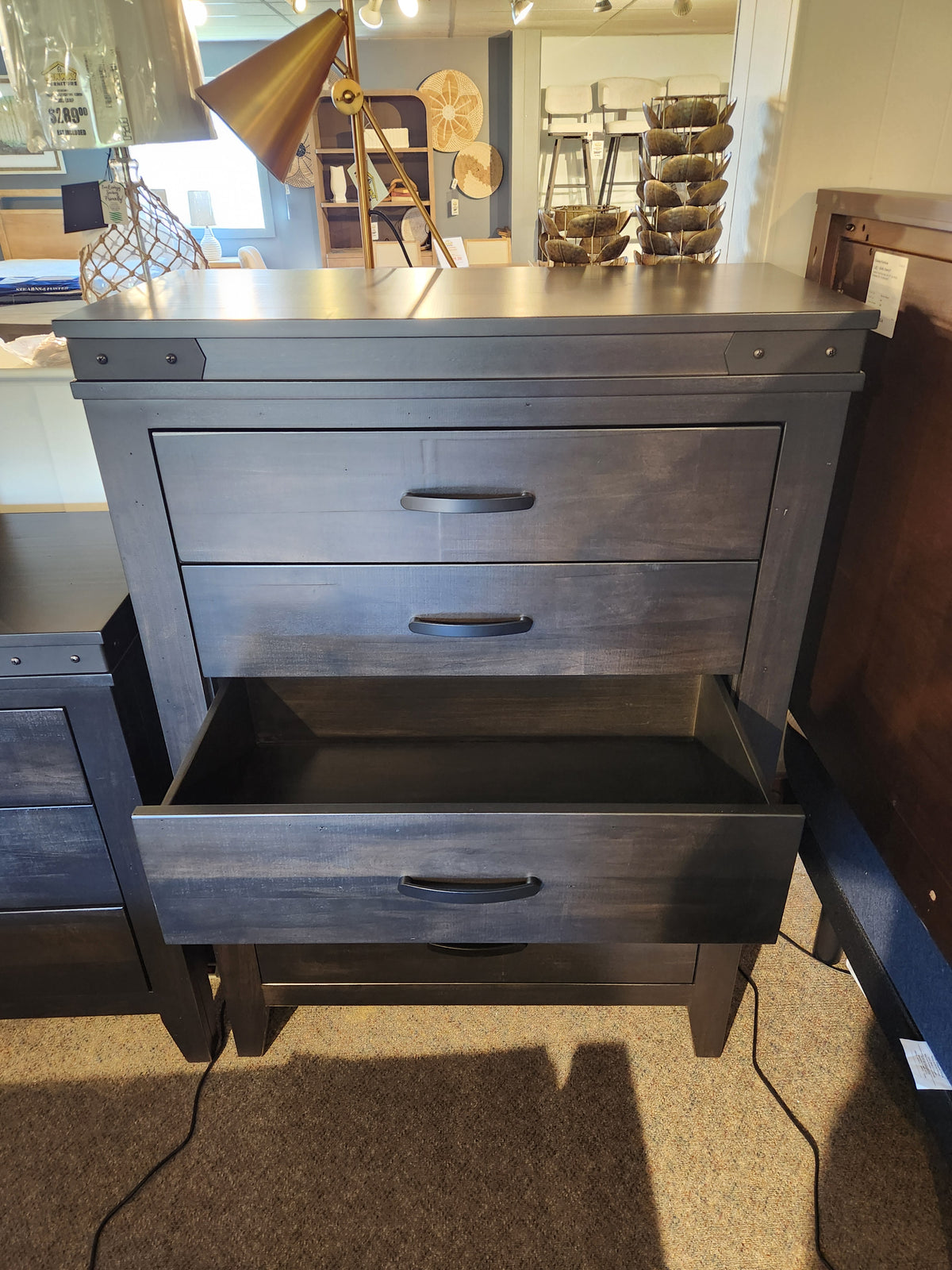The Handstone Chattanooga 5 Drawer Highboy, shown in Heritage Maple Charcoal with metal hardware, is on display.