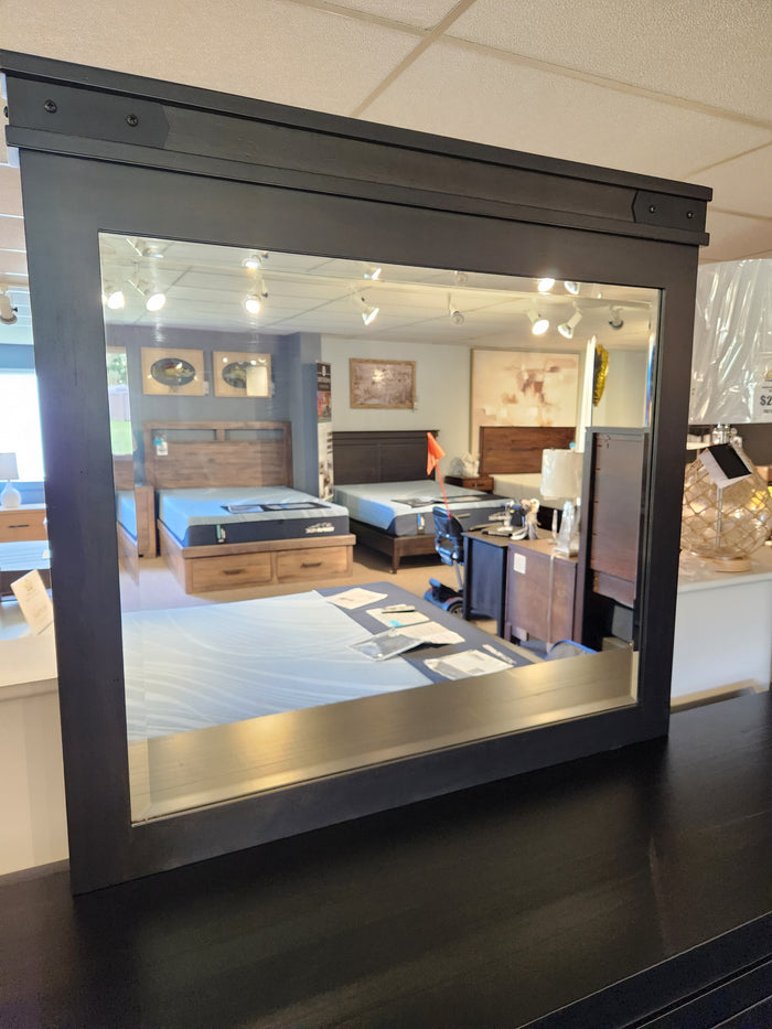 The Handstone Chattanooga Landscape Mirror has metal hardware and reflects beds, furniture, and displayed items.