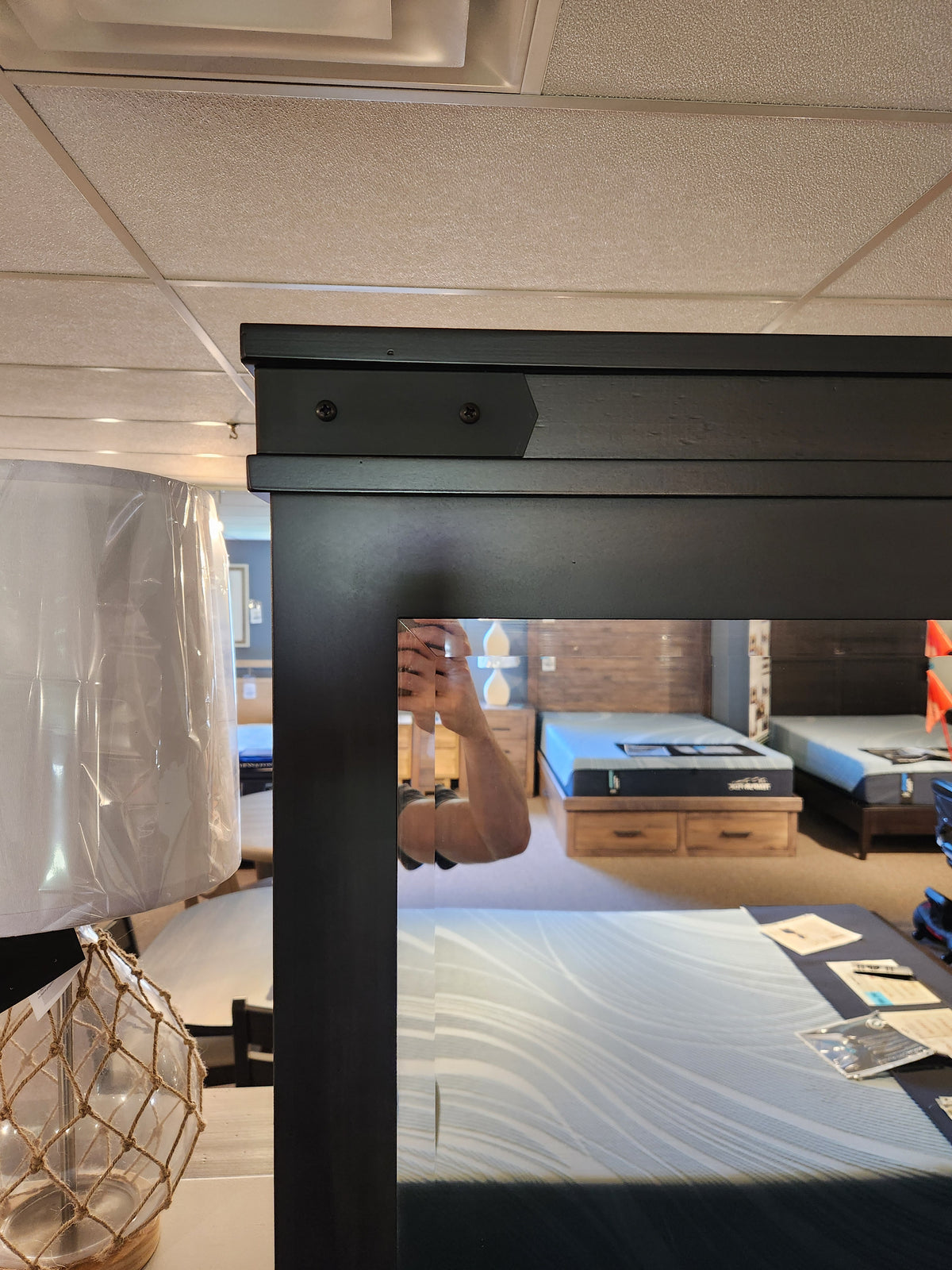 Person taking a photo in a mattress store, reflected in a Handstone Chattanooga Landscape Mirror.