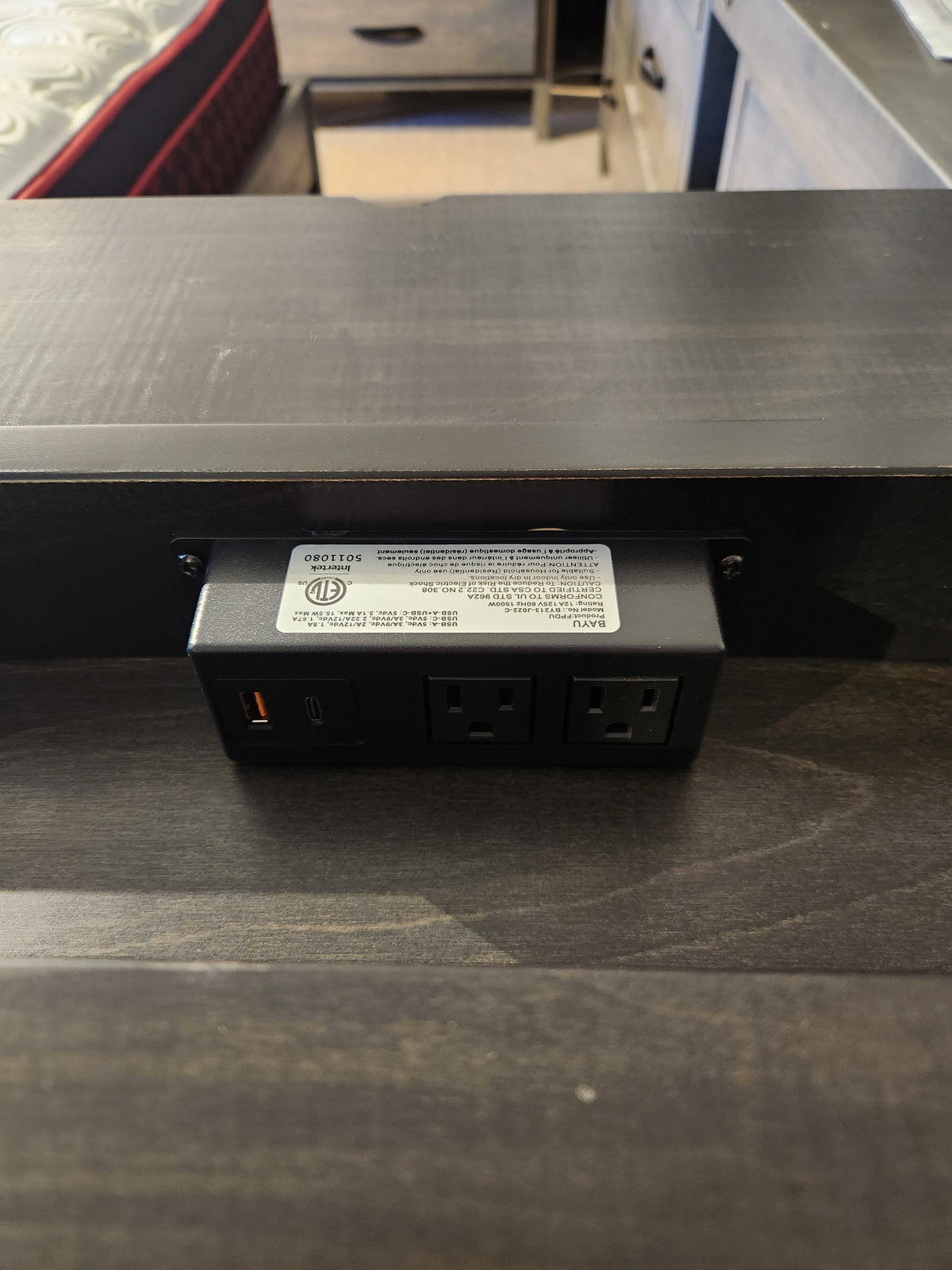 Close-up of built-in outlet in the Handstone Chattanooga Power Nightstand in Heritage Maple Charcoal finish.