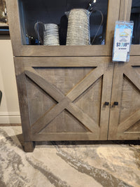 The Barrett Cabinet by Mercana features crossed panel doors, metal pitchers inside, and costs $2,799.00.