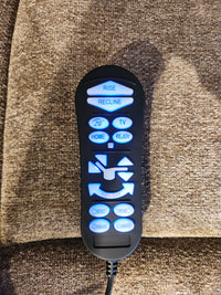 Remote control for Golden Venice PL447 Lift Chair on brown upholstery, with lit buttons and Twilight Tilt Technology.