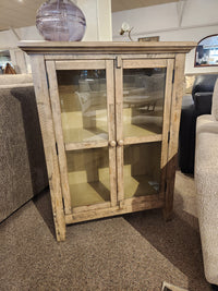 The Jofran Rustic Shores 2 Door Accent Cabinet with glass doors and two shelves sits between two sofas.