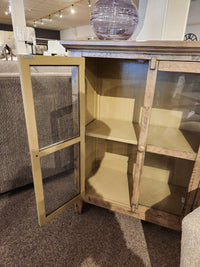 The Jofran Rustic Shores 2 Door Accent Cabinet stands open, showing two empty shelves in a showroom.