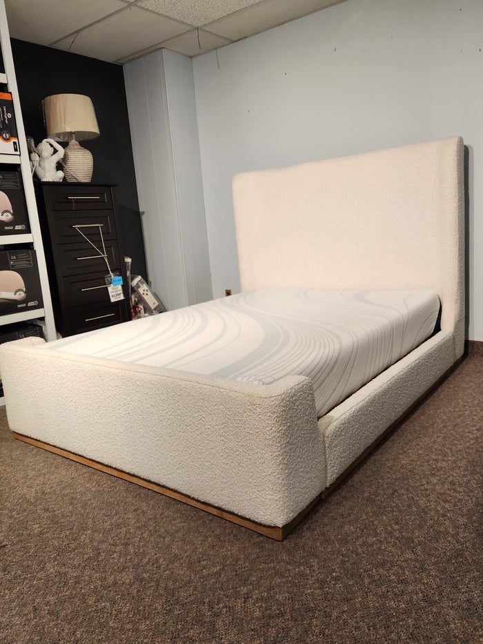 The Fashion Nala Bed, a cream boucle platform with wingback headboard, sits in a carpeted showroom corner.