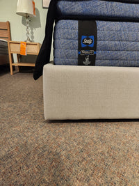 A close-up of a Sealy mattress on a Palliser EQ3 Nara Queen Bedframe with modern upholstered headboard.