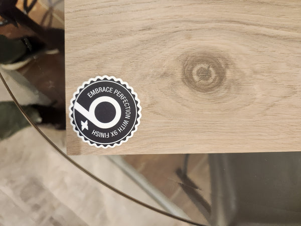 A black and white sticker on wood reads "EMBRACE PERFECTION WITH 9X FINISH" beside Posh Plank Windsor flooring by BECKHAM BROTHER'S.