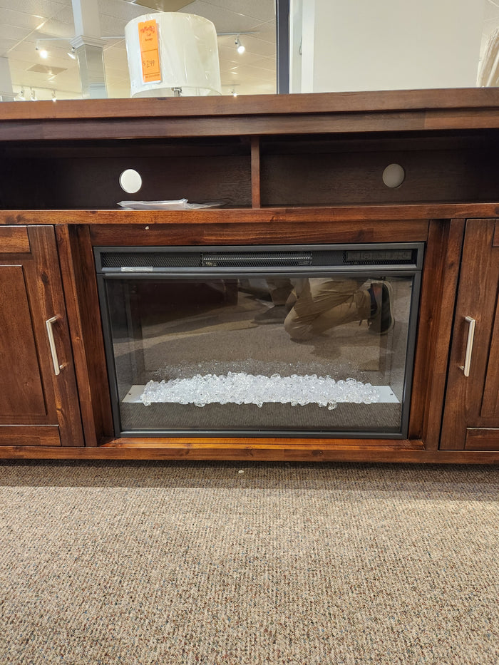 The Jofran Urban Icon Electric Fireplace Media Console features open shelves, clear stones, and a cozy ambiance for media storage.
