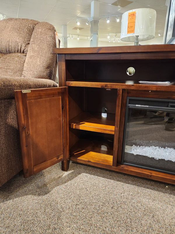 Jofran Urban Icon Electric Fireplace Media Console features open shelving for media storage beside a recliner.
