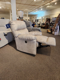 The Best 7MP84 Ellisport Power Space Saver Recliner in beige is extended in a showroom among other chairs and displays.