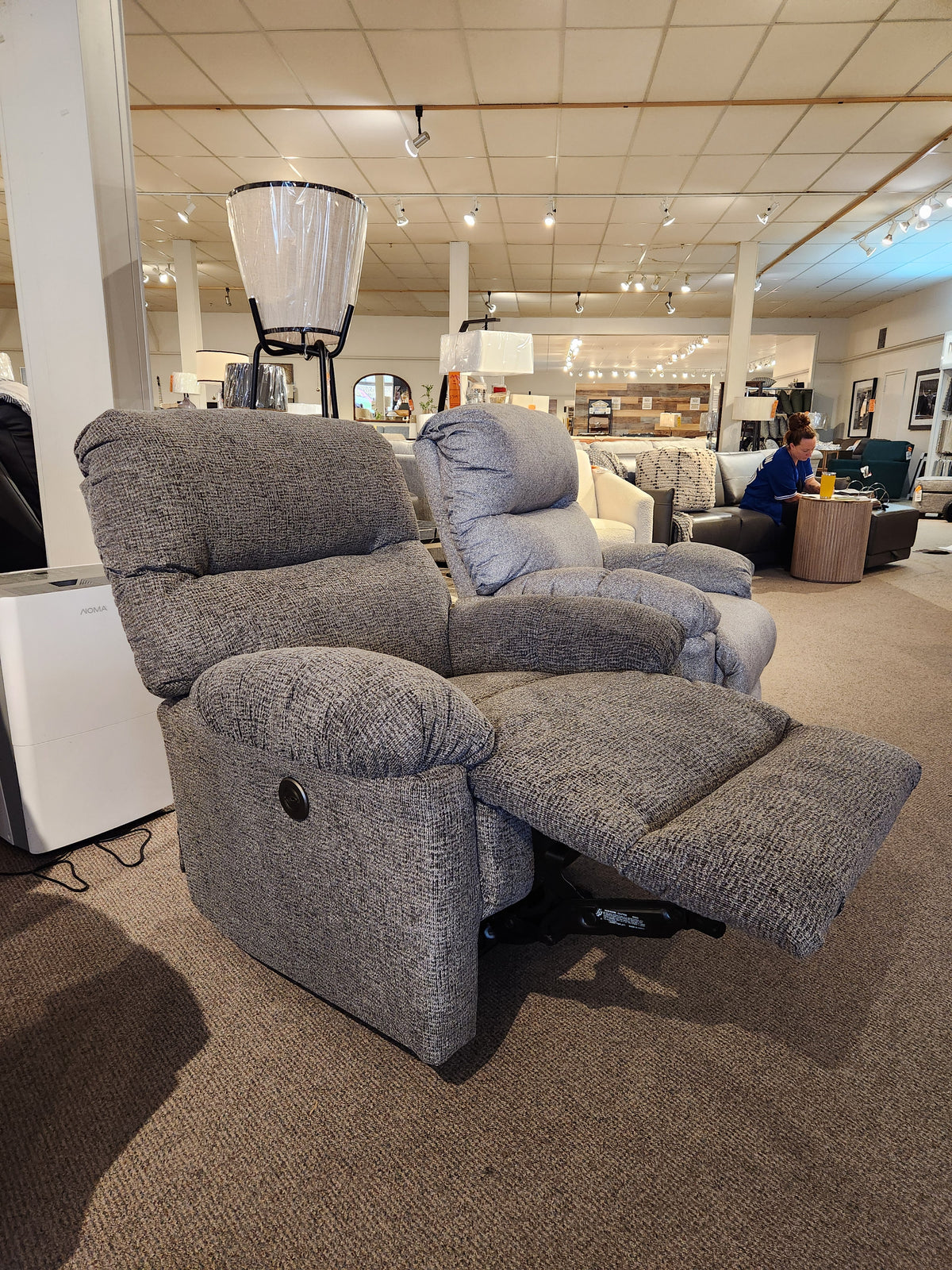 Best 7MP84 Ellisport Power Space Saver Recliner with footrest extended, shown in a showroom with other furniture.