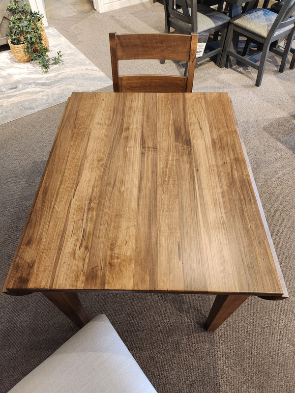 A Handstone 3 Piece Parker Dining Table Set with matching chair displayed on a carpeted showroom floor.