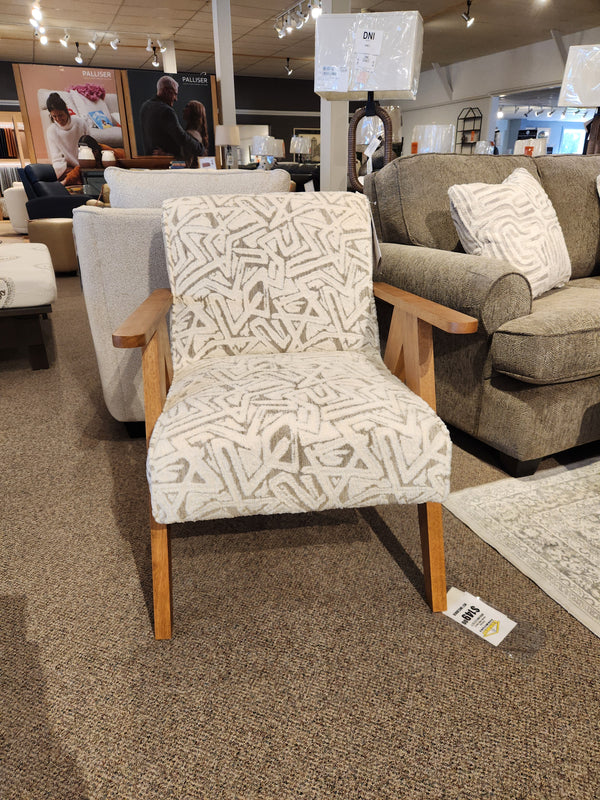 The Bayden 3180 Chair by Best features modern style and wooden sawhorse legs, showcased in a furniture showroom.