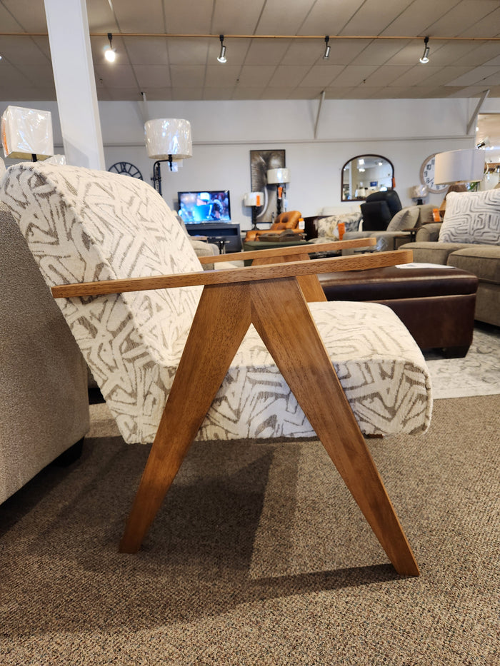 A wooden tray table with sawhorse legs sits over a Bayden 3180 Chair by Best in a showroom.