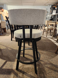 Barry Swivel Bar Stool by Amisco: gray cushion, black steel legs, scratch-resistant finish, shown with other chairs.