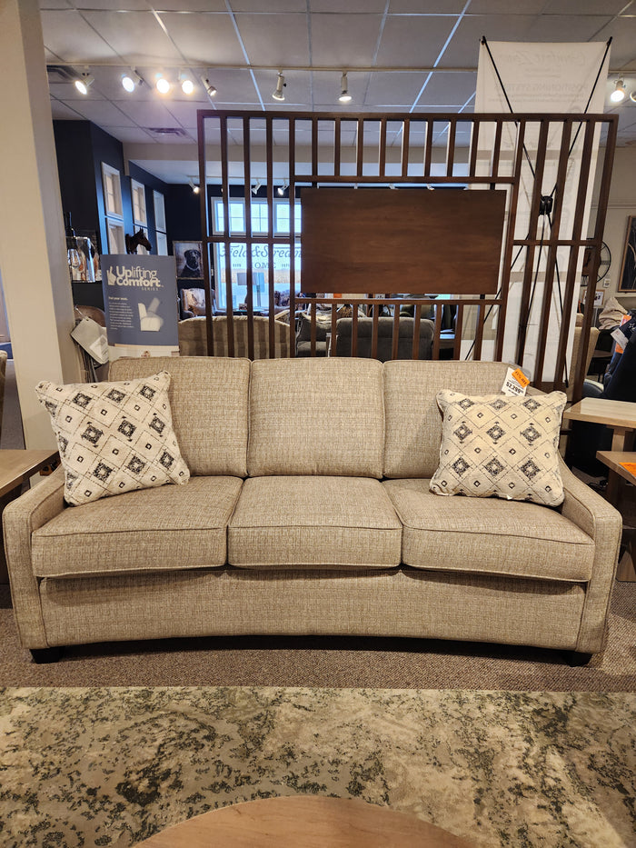 The Superstyle 9670 Sofa in beige, medium-firm with two throw pillows, shown in a Canadian furniture showroom.