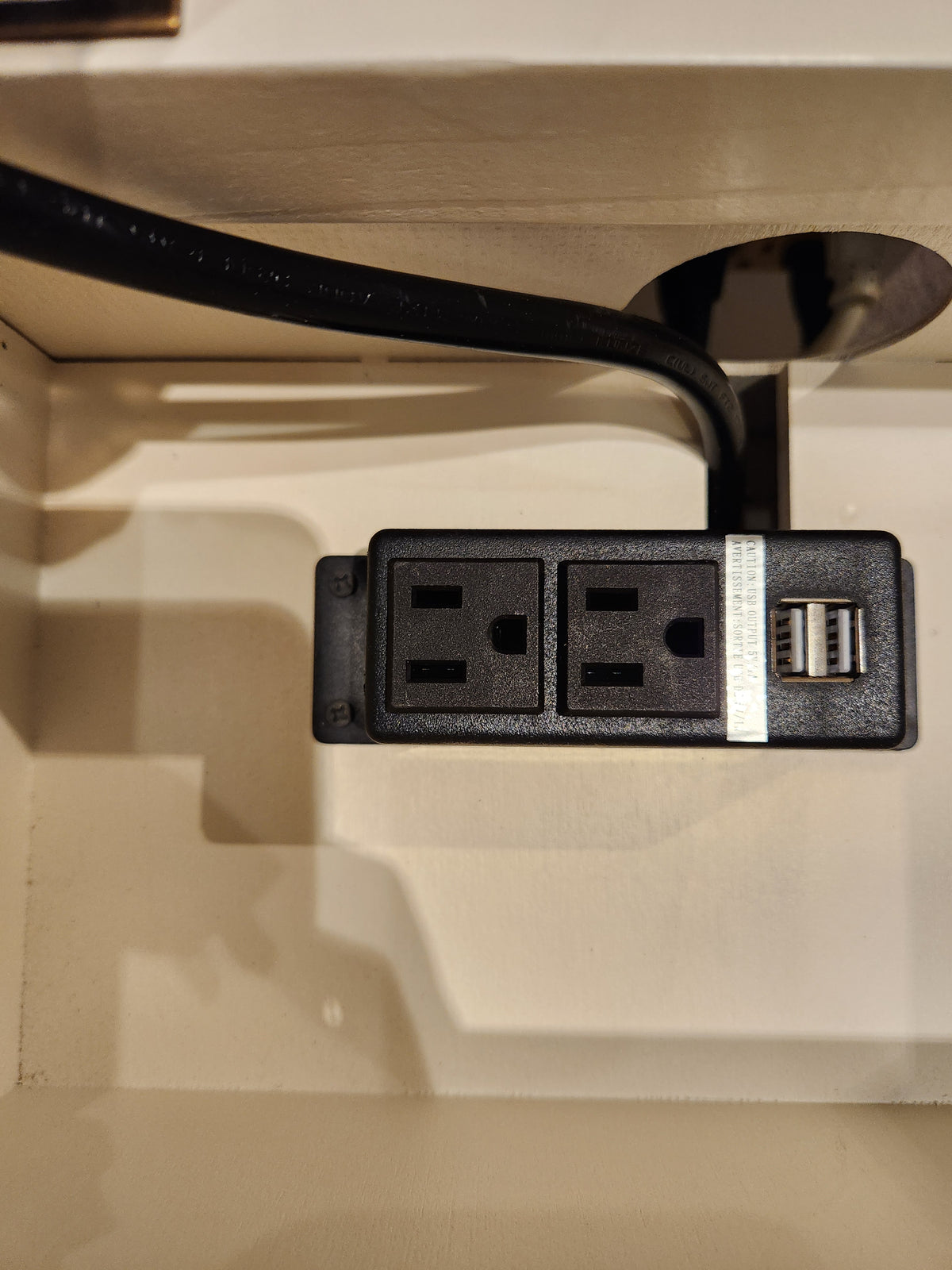 Jofran 1706 Madison County Power Chairside End Table features a black outlet with 2 sockets and USB ports on beige surface.