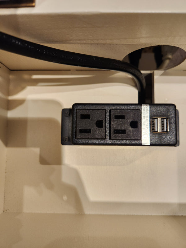 Jofran 1706 Madison County Power Chairside End Table features a black outlet with 2 sockets and USB ports on beige surface.