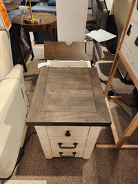 The Jofran 1706 Madison County Power Chairside End Table with barn door accents is displayed in a store.