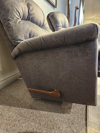 A La-Z-Boy 515 Lancer Rocker Recliner in gray with a wooden lever sits on a carpeted floor by a wall.