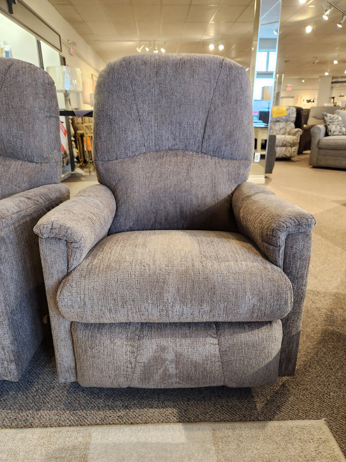 The La-z-boy 795 Mercury Wall-A-Way Recliner in gray is displayed in a furniture showroom among other chairs.