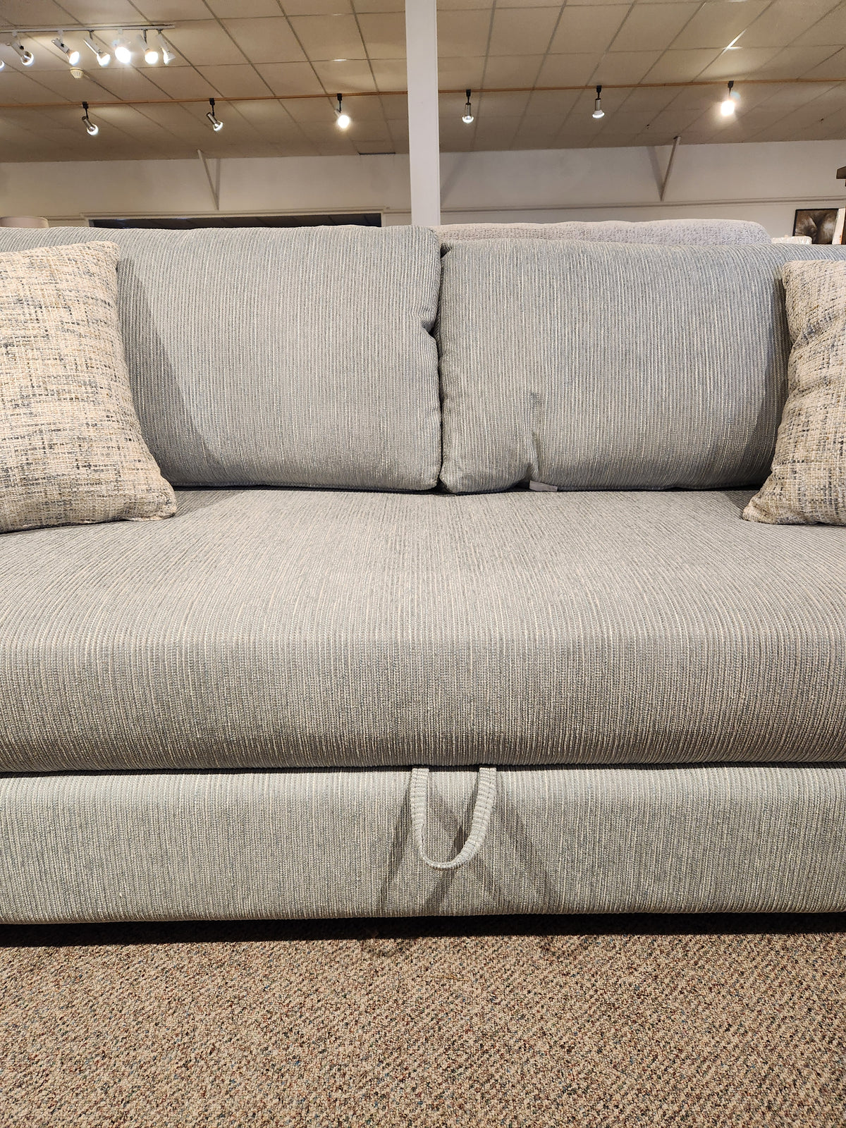 Decor-rest 2465 Queen Sofabed in gray upholstery with 2 matching pillows, shown front-facing in showroom.