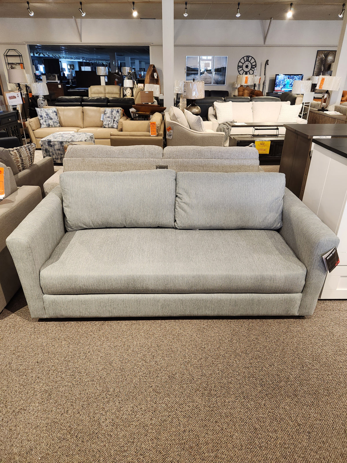 Decor-rest 2465 Queen Sofabed in light gray Canadian upholstery shown in showroom with other seating options.