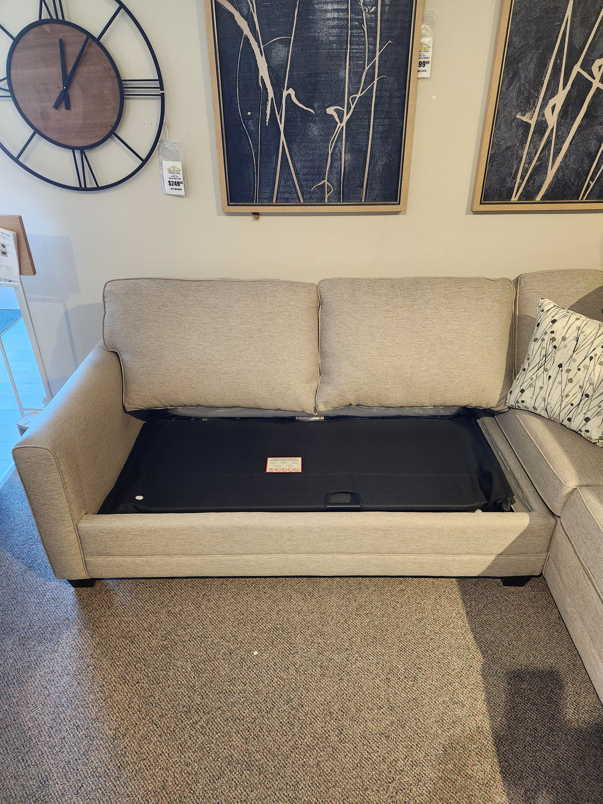 Superstyle 1014 Trinity Double Sofabed Sectional with cushions removed reveals black frame in a stylish showroom.