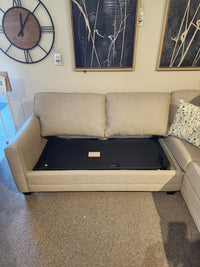 Superstyle 1014 Trinity Double Sofabed Sectional with cushions removed reveals black frame in a stylish showroom.