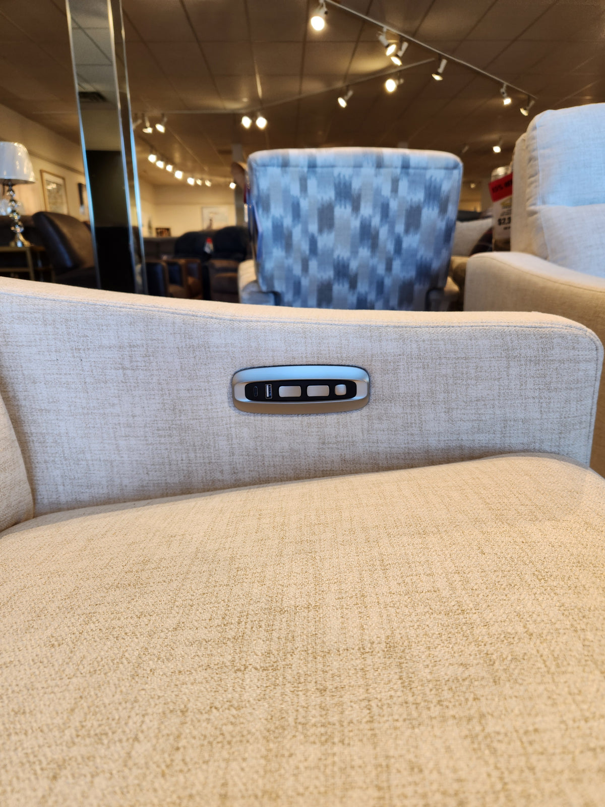 Close-up of La-Z-Boy 810 Quinault Power Reclining Loveseat with Zero G & Headrest and armrest control panel in a store.