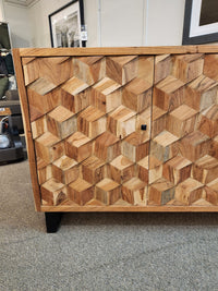 Jofran Geometrix Accent Cabinet with a 3D block pattern door, displayed on carpet in a showroom.