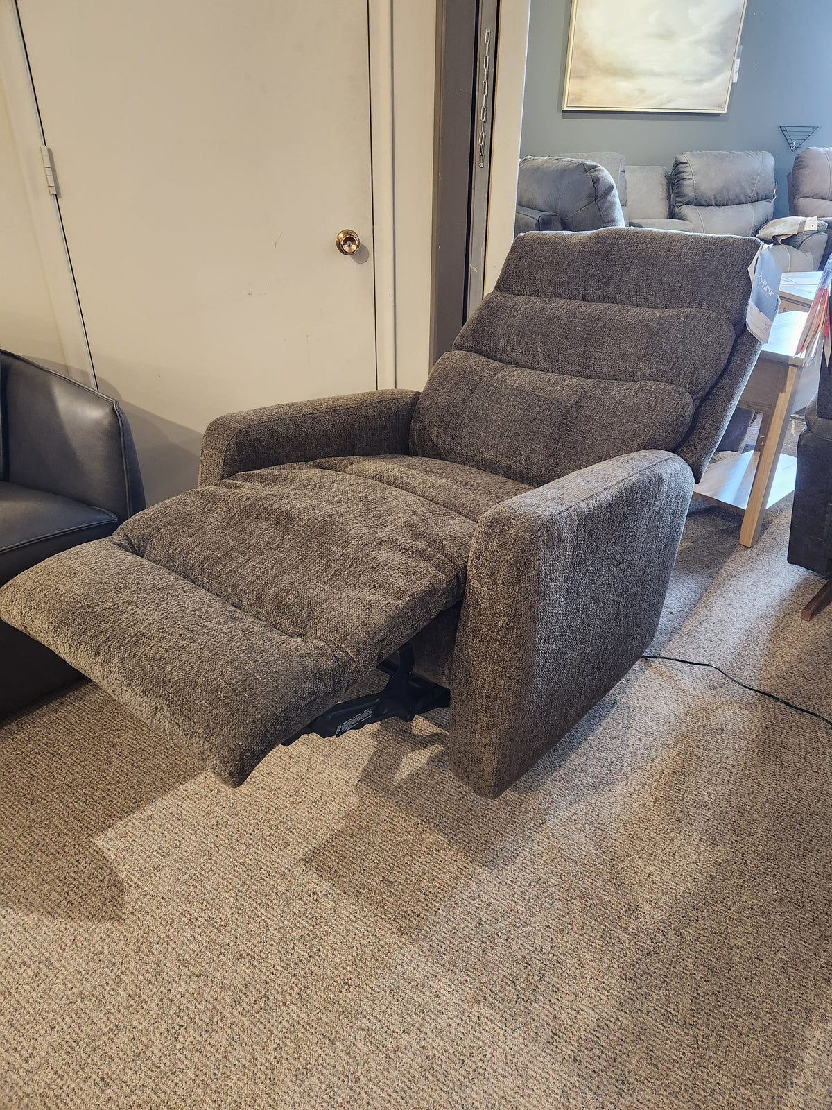 A Best 9NP34 Power Space Saver Recliner in gray is extended in a carpeted room with other furniture visible.