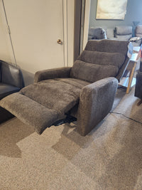 A Best 9NP34 Power Space Saver Recliner in gray is extended in a carpeted room with other furniture visible.