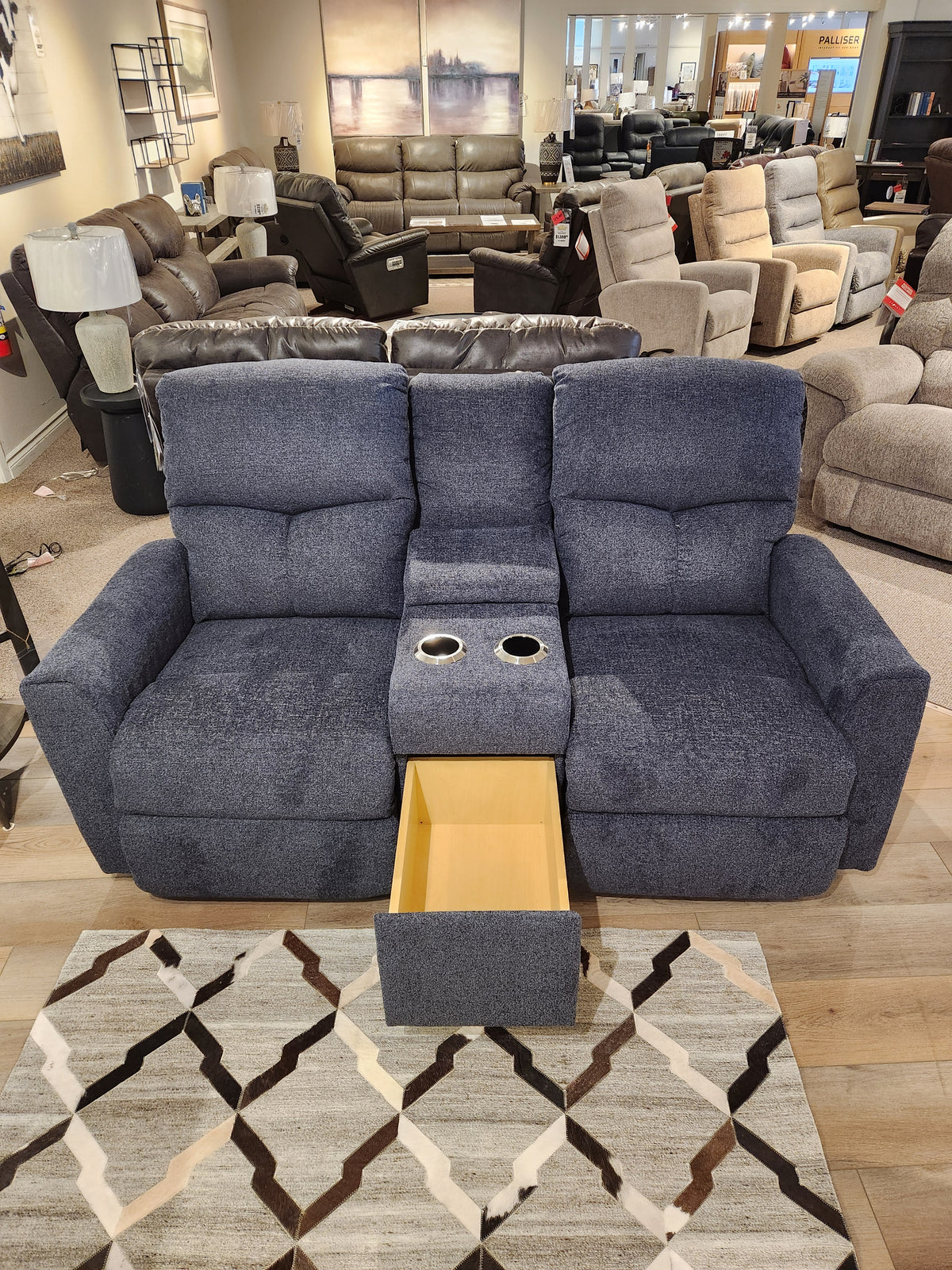 The La-z-boy 780 Hawthorn Reclining Loveseat With Console is displayed in a showroom with chaise seats and cup holders.