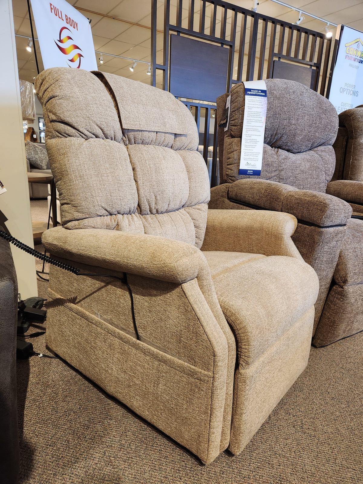 Golden Aurora PL480 Power Lift Chair in beige upholstery with padded backrest and arms, shown in a showroom.
