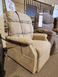 Golden Aurora PL480 Power Lift Chair in beige upholstery with padded backrest and arms, shown in a showroom.