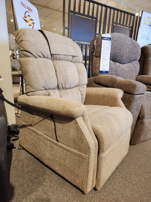 Golden Aurora PL480 Power Lift Chair in beige upholstery with padded backrest and arms, shown in a showroom.