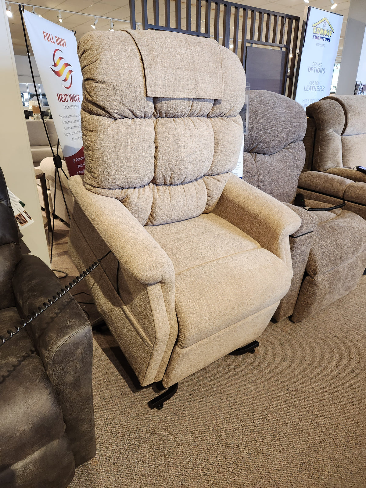A Golden Aurora PL480 Power Lift Chair in beige is shown in a showroom beside other power lift recliners.