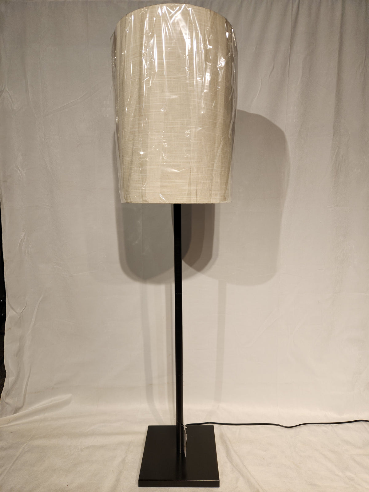 The Adesso Lamp Liam Floor Lamp features a dark bronze finish, square base, and cylindrical fabric shade.