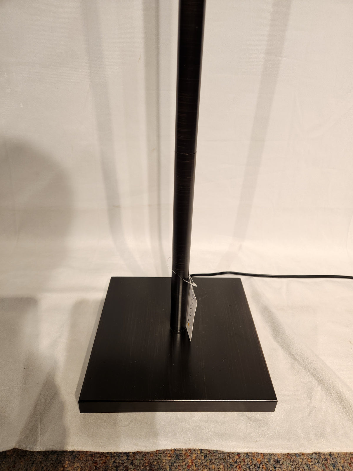 The Adesso Liam Floor Lamp features a dark bronze finish, square base, and power cord extending from the bottom.
