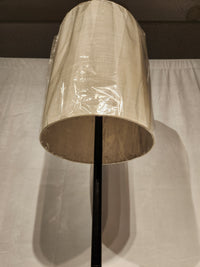 The Adesso Liam Floor Lamp features a beige fabric shade with plastic cover, shown against a white background.